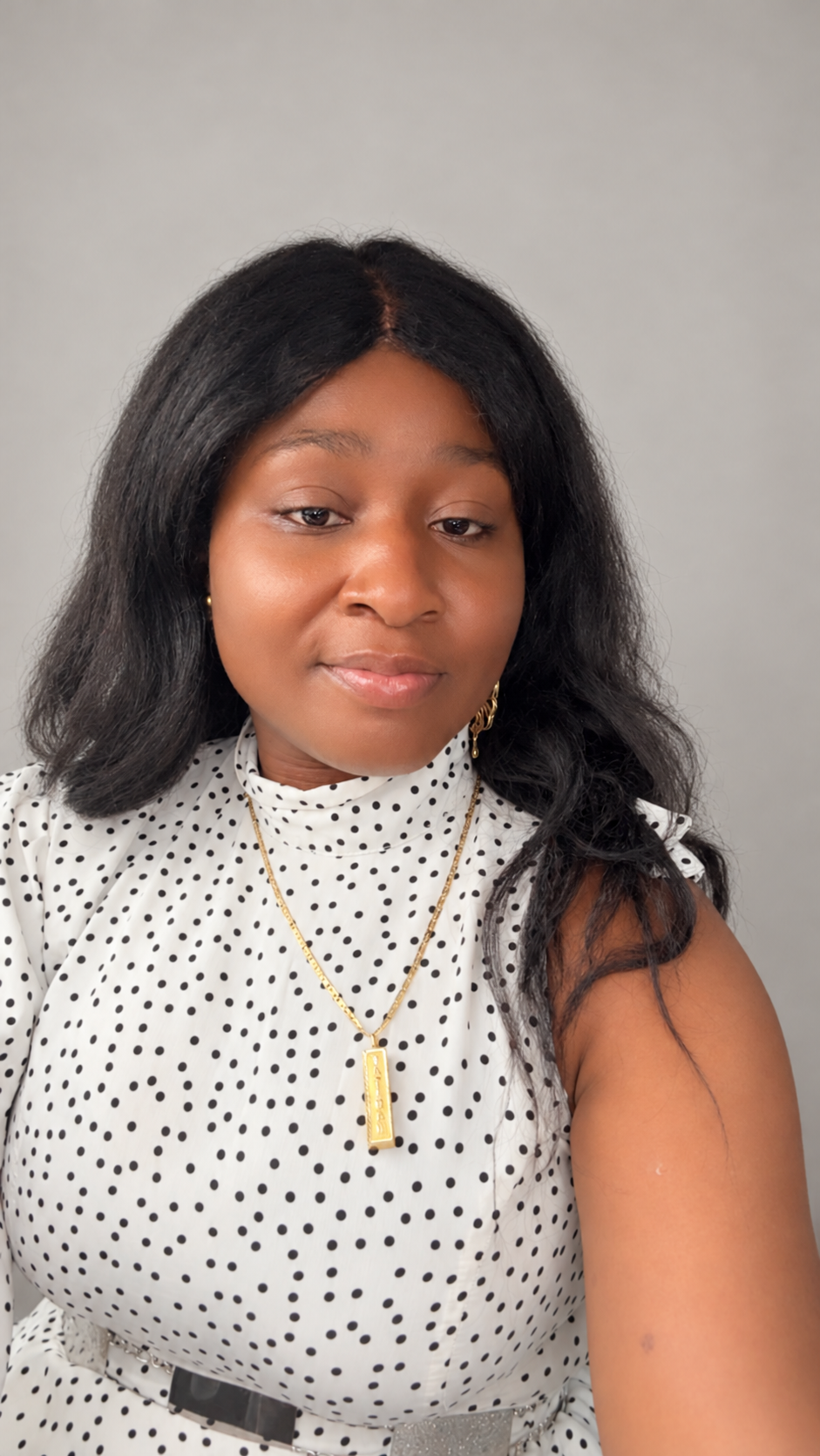 Jojo Sulaimon smiling in a white polka-dot top