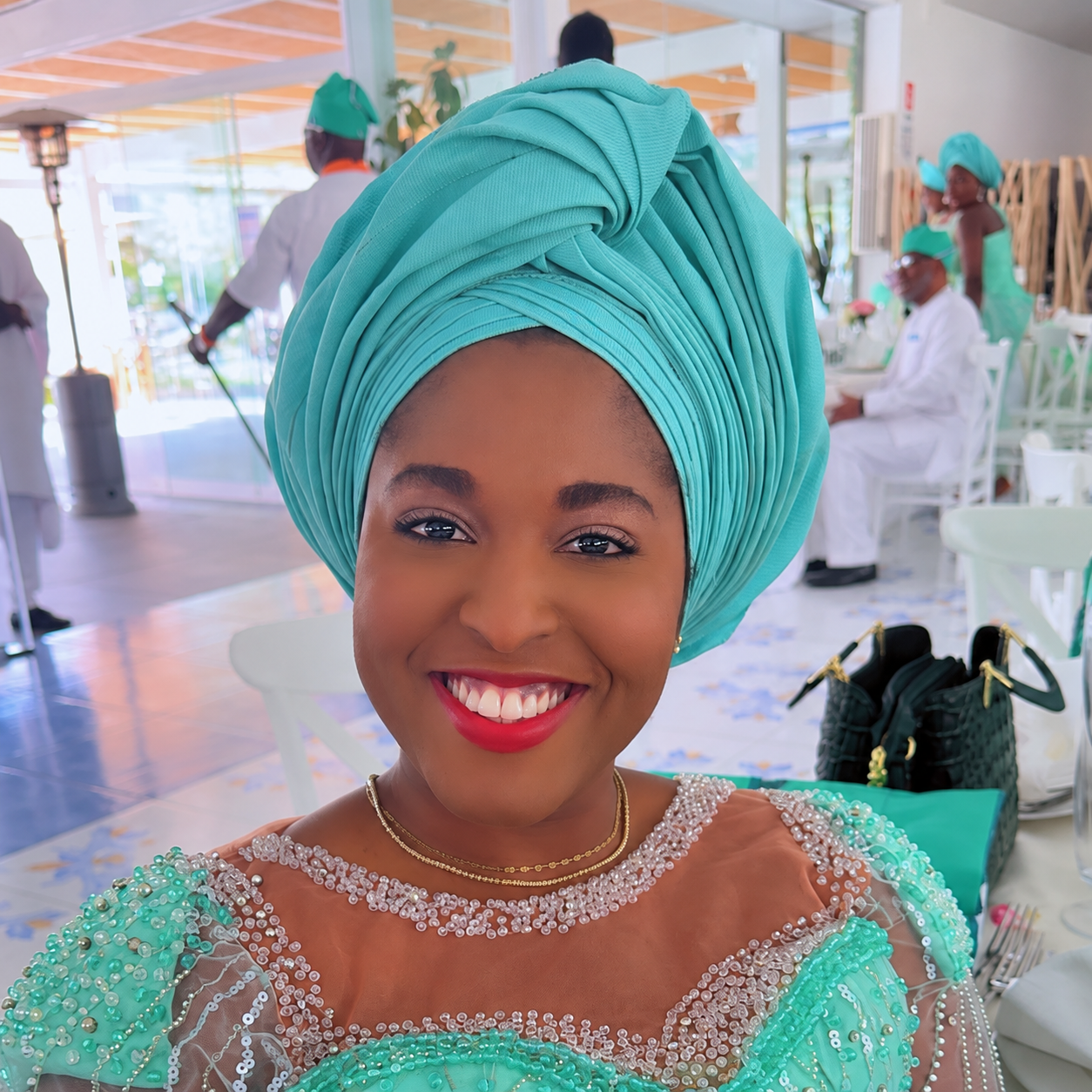 Dr. Tomy smiling in turquoise attire